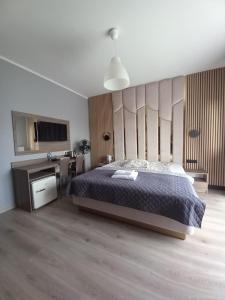 sypialnia z łóżkiem i telewizorem w obiekcie Villa Lima w Ustce