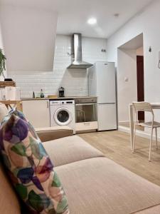 sala de estar con sofá y cocina con nevera. en Apartamentos La Albariza Jerez Centro, en Jerez de la Frontera