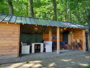 eine Holzhütte mit einem Tisch und Stühlen in der Unterkunft mooie familie groepsaccomodatie aan de bosrand in Overloon