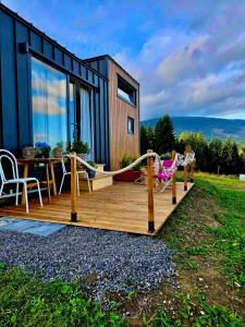 a deck with a hammock and a house at Domek w górach balia Tiny House Polana Widokówka in Lipnica Wielka