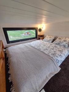 a bedroom with a bed and a large window at Domek w górach balia Tiny House Polana Widokówka in Lipnica Wielka