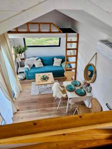 ein Wohnzimmer mit einem blauen Sofa und einem Tisch in der Unterkunft Domek w górach balia Tiny House Polana Widokówka in Lipnica Wielka