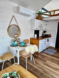 a kitchen with a table and chairs and a mirror at Domek w górach balia Tiny House Polana Widokówka in Lipnica Wielka