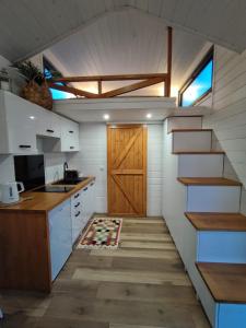 kuchnia ze schodami i drzwiami w pokoju w obiekcie Domek w górach balia Tiny House Polana Widokówka w mieście Lipnica Wielka