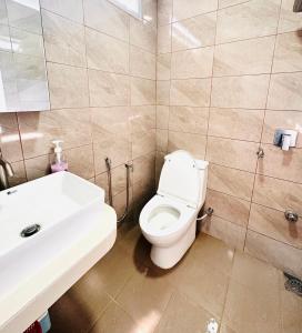 La salle de bains est pourvue de toilettes blanches et d'un lavabo. dans l'établissement The Ruuma Beach, à Bachok
