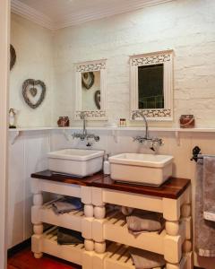 a bathroom with two sinks on a wooden shelf at Anglers Court in Dullstroom