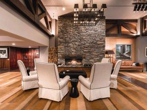 ein Wohnzimmer mit Stühlen und einem Kamin in der Unterkunft Hotel St Moritz Queenstown - MGallery by Sofitel in Queenstown