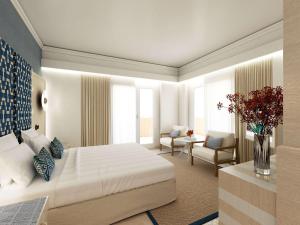 a bedroom with a large white bed and a chair at Pullman Almar Timi Ama Resort & Spa in Villasimius