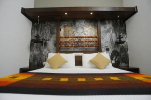 a bedroom with a large bed with a wooden headboard at Serendib Signature Resort in Digana