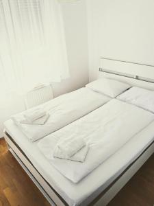 a white bed with white sheets and towels on it at DoMa-Lu apartment with free parking in Velika Mlaka