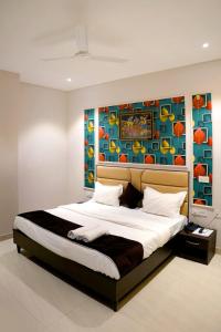 een slaapkamer met een groot bed en een schilderij aan de muur bij Hotel Swastik 5 Minutes walking From Golden Temple in Amritsar