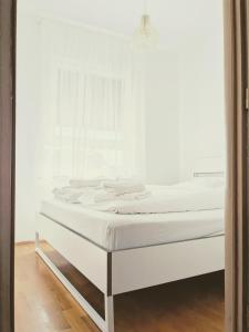 a white bed in a room with a window at DoMa-Lu apartment with free parking in Velika Mlaka