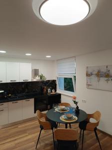 a kitchen with a table and chairs in a kitchen at Studio apartman Peti in Varaždin
