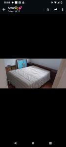 uma fotografia de uma cama num quarto em Peruíbe casa 150 metros praia 3 dormitórios casa independente em Peruíbe