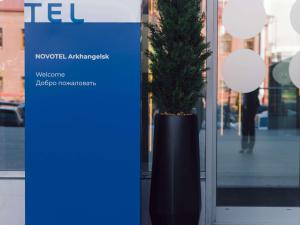 a potted tree sitting in front of a door at Novotel Arkhangelsk in Arkhangelsk
