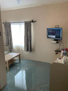 a living room with a television on the wall at Joets Guesthouse in Bogmolo