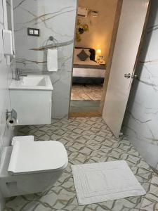 a bathroom with a toilet and a sink and a bed at Joets Guesthouse in Bogmolo