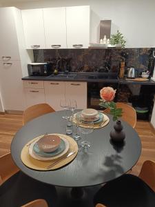 a dining room table with plates and wine glasses at Studio apartman Peti in Varaždin