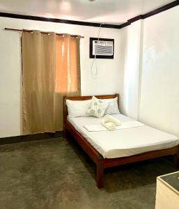 a small bed in a room with a window at Hidden Gem Siargao in General Luna