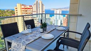 a table with plates and glasses on a balcony at Torre Lugano - Gran terraza con vistas in Benidorm