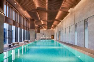 a large swimming pool in a building with windows at Hyatt Regency Hangzhou International Airport in Hangzhou