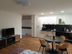 a living room with a table and chairs and a kitchen at Studio apartman Krležina in Varaždin