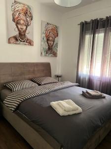 a bed in a bedroom with two pictures on the wall at Sea View Residence by MD in Alexandroupoli