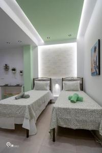sypialnia z 2 łóżkami i zieloną poduszką w obiekcie 'The Mint' House Project In Athens w Atenach