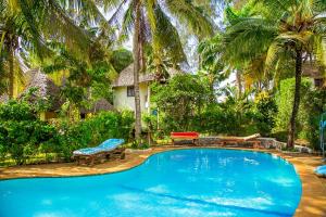 una piscina con bancos y una casa en Room Sawa, en Diani Beach