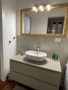 een badkamer met een wastafel en een spiegel bij Maison Lulu- Appartamento nuovo in Pescara
