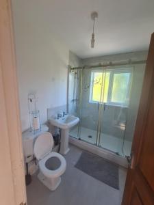 y baño con aseo, lavabo y ducha. en L & J Escapes - 8 Bedrooms suitable for Contractors and Families- Private parking available for 6 vehicles en Coseley