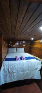 a large bed with two purple pillows on it at familykomodocruise in Labuan Bajo