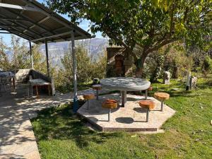 a table and some stools sitting in the grass at Rubina Bed and Breakfast in Tatʼev