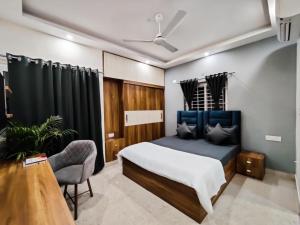 a bedroom with a bed and a desk and a chair at BluO Studios - Koramangala in Bangalore