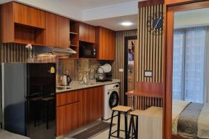a kitchen with wooden cabinets and a bed in a room at CB408 Apartament Beach condo 777 in Phuket