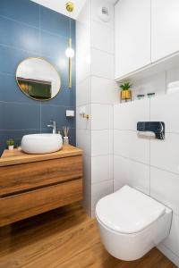 Łazienka z białą toaletą i umywalką w obiekcie Apartament Royal Premium - parking podziemnym gratis, ścisłe centrum - by Kairos Apartments w mieście Gliwice
