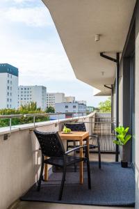 balkon ze stołem i krzesłami na dachu w obiekcie Apartament Royal Premium - parking podziemnym gratis, ścisłe centrum - by Kairos Apartments w mieście Gliwice