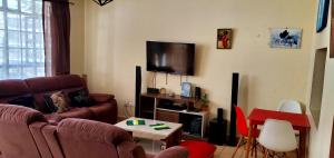 a living room with a couch and a flat screen tv at 2 Bedroom Apartment in Langata in Nairobi