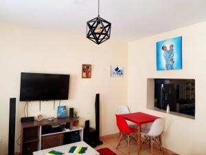 a living room with a red table and a tv at 2 Bedroom Apartment in Langata in Nairobi