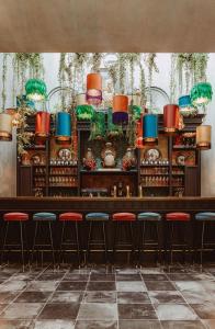 科特賴克的住宿－Cobergher Hotel，餐厅内带红色凳子的酒吧