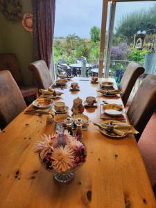 una mesa de madera con platos de comida. en Swallows Rest, en Weymouth