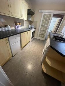a kitchen with white cabinets and a black counter top at Lovely 4 bedroom Victorian house with back courtyard in Stoke on Trent