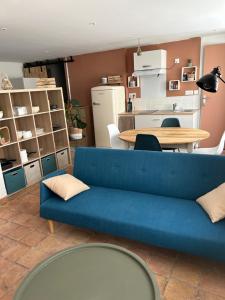 uma sala de estar com um sofá azul e uma mesa em Appartement coeur de ville -Clim, ascenseur, wifi- em Avignon