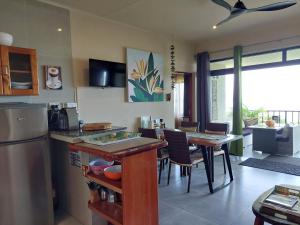 a kitchen with a counter and a table with chairs at La Vida Selfcatering Apartements in Mahe