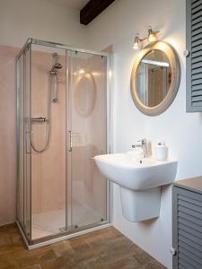 ein Bad mit einer Dusche, einem Waschbecken und einem Spiegel in der Unterkunft Fermo della Guazzona in Busseto