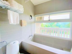 吉安的住宿－海洋曼波民宿 ，一间带白色卫生间的浴室和窗户。