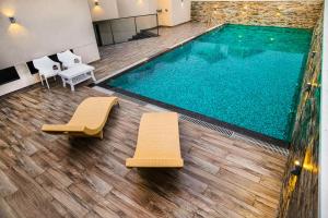 a swimming pool with two chairs and a swimming pool at KKM INTERNATIONAL in Trivandrum