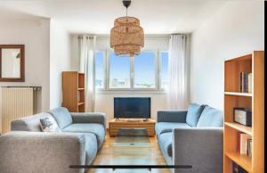 a living room with two blue couches and a television at Toulon entre Mer et Terre in Toulon