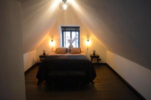 um quarto com uma cama grande num sótão em Goudgenog em Appingedam