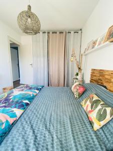 Een bed of bedden in een kamer bij Évasion Tropicale - Villa d'Artiste avec Jacuzzi Privé dans un jardin Exotique